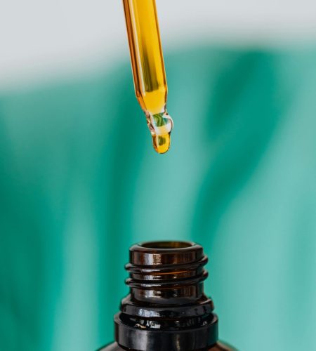 Detailed view of an amber glass bottle and dropper used in laboratory or medical setting, illustrating chemical experimentation.